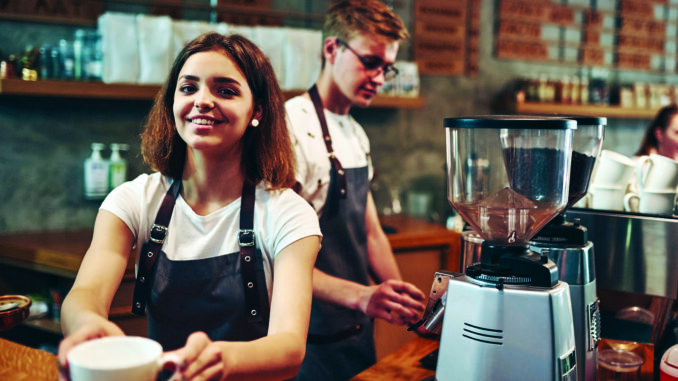 Your drink is ready. Two young cafe workers indoors. Conception of business and service