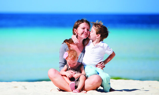 Young mother with her two kids on tropical beach vacation