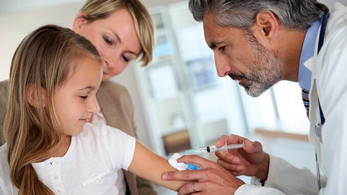 Young girl receiving vaccination in doctor's office