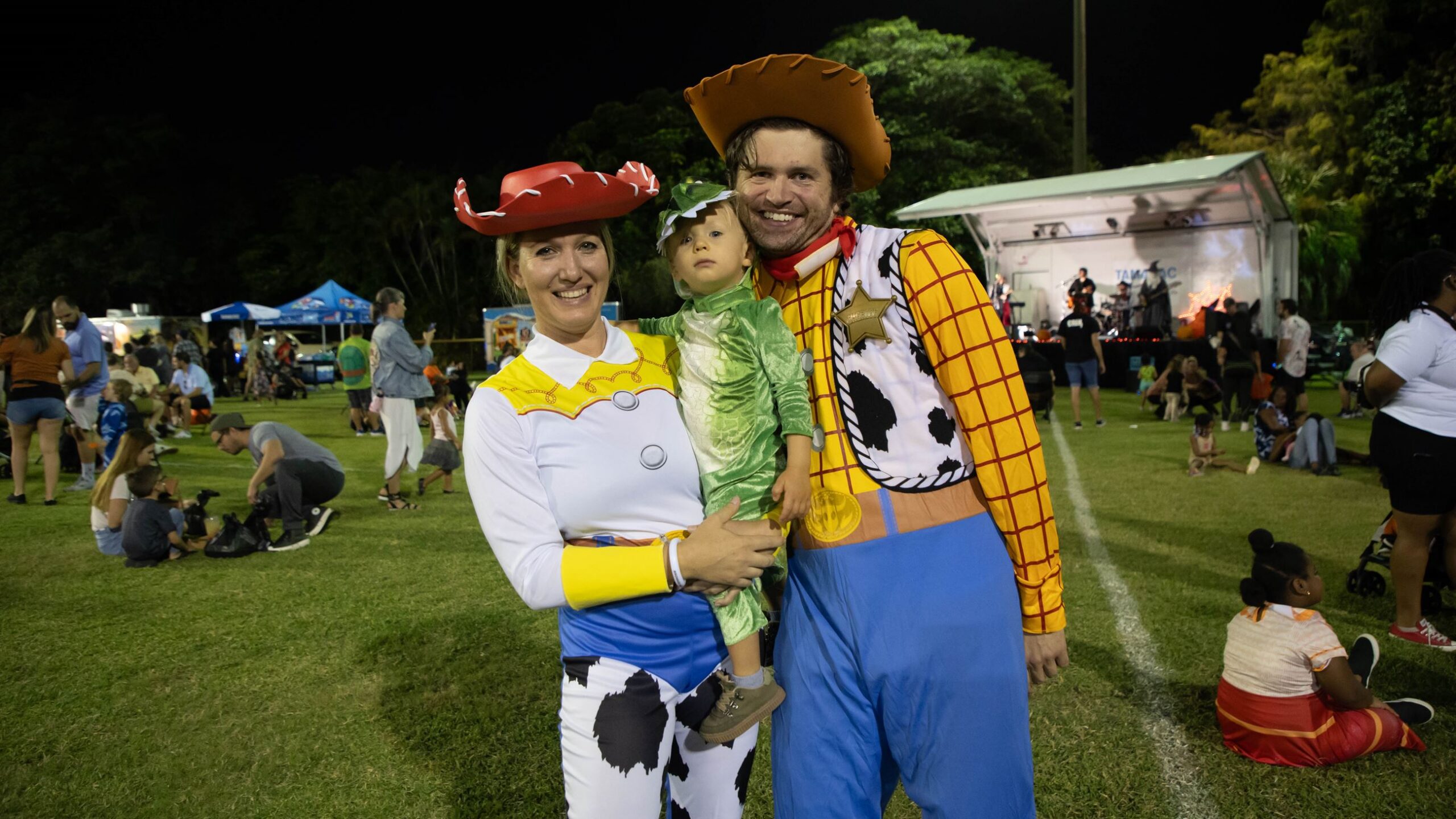Family dressed in costumes, smiling and looking at the camera.